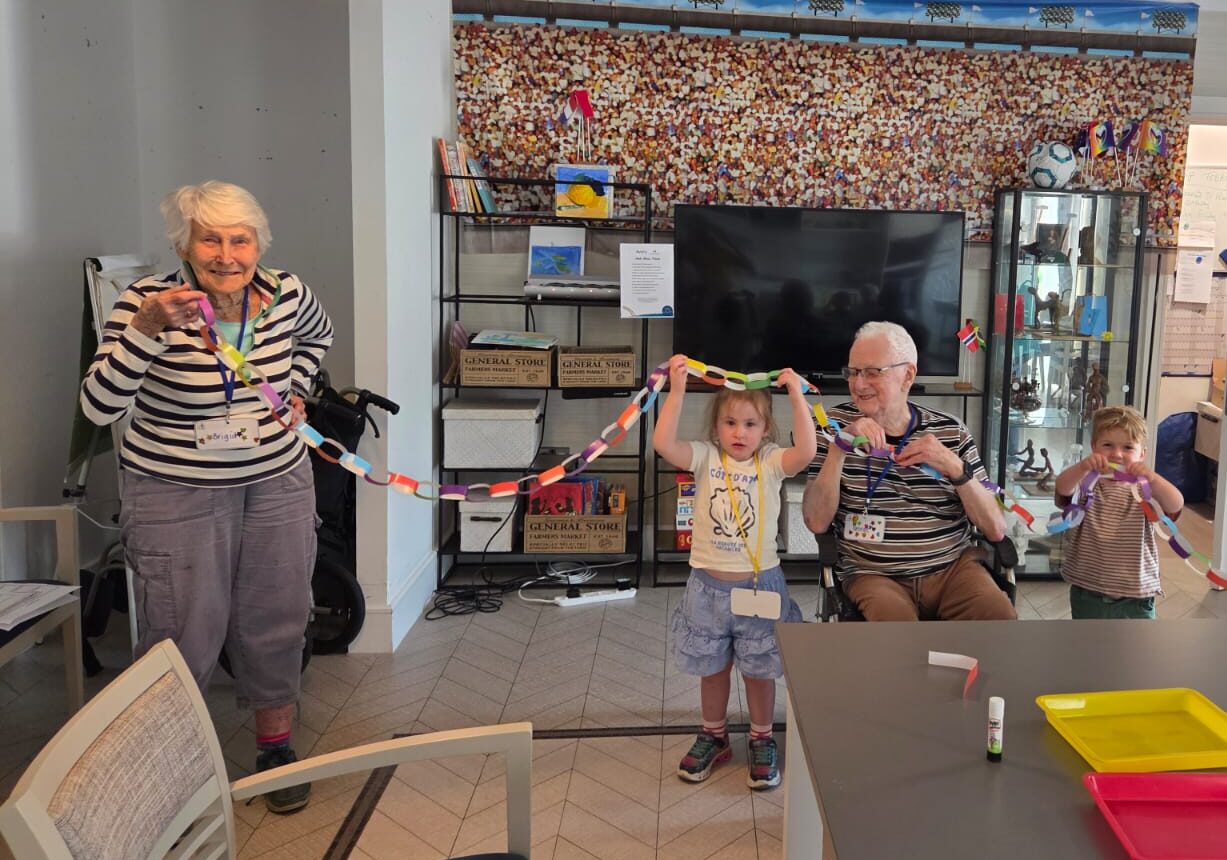Adults and children holding paper chain