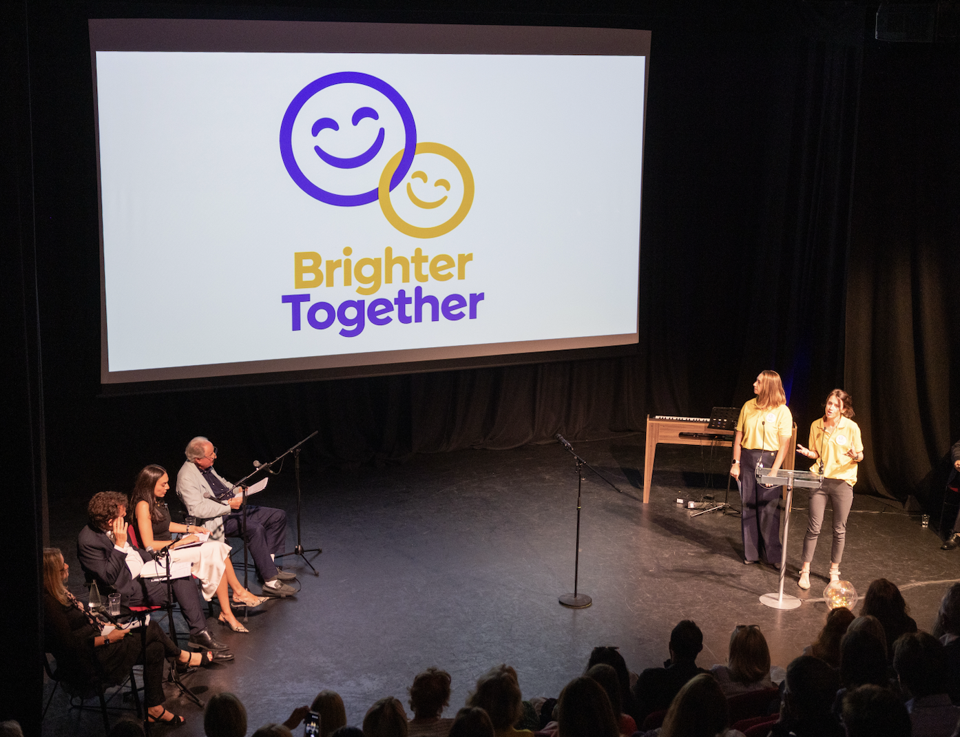 Brighter Together on stage speaking to an audience and panel